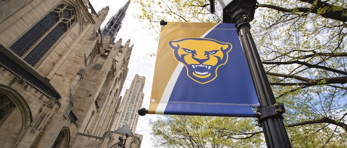 Cathedral of Learning next to a Pitt Panther light post banner